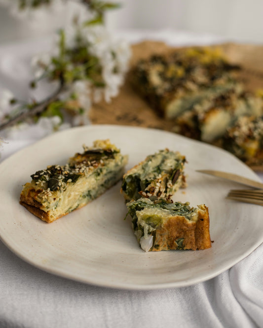 Savory vegetable tart slices on a white plate.